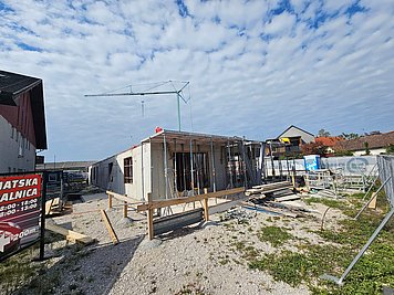 Gradbišče Zdravstvenega centra Podpeč Gradnja Večnamenskega zdravstvenega centra Podpeč z vidno betonsko konstrukcijo objekta in gradbiščno opremo